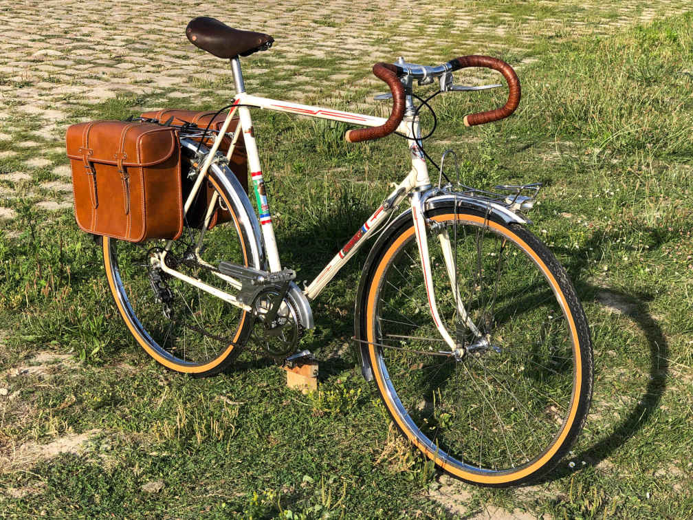 vélo de type randonneuse avec des sacoches en cuir marron