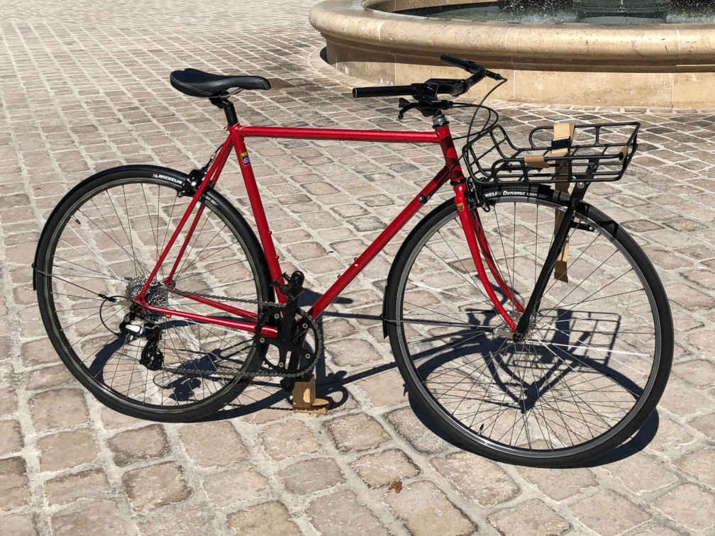Vélo urbain rouge avec porte bagage avant Basil