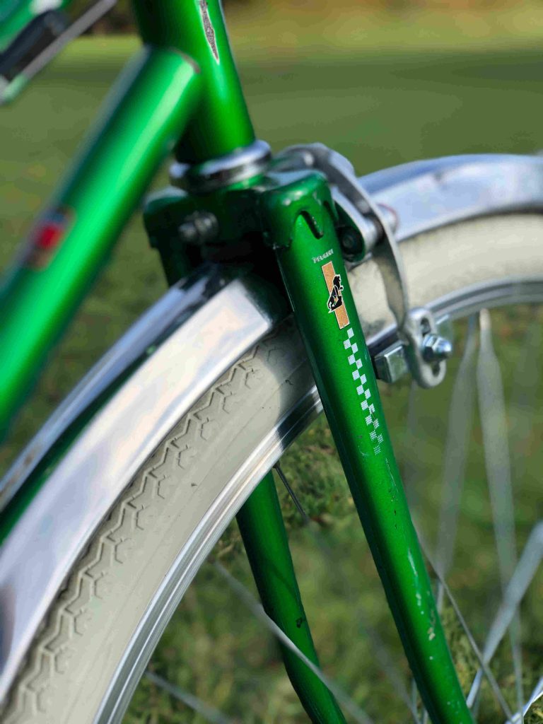 logo Peugeot sur la fourche d'un vélo de ville vert