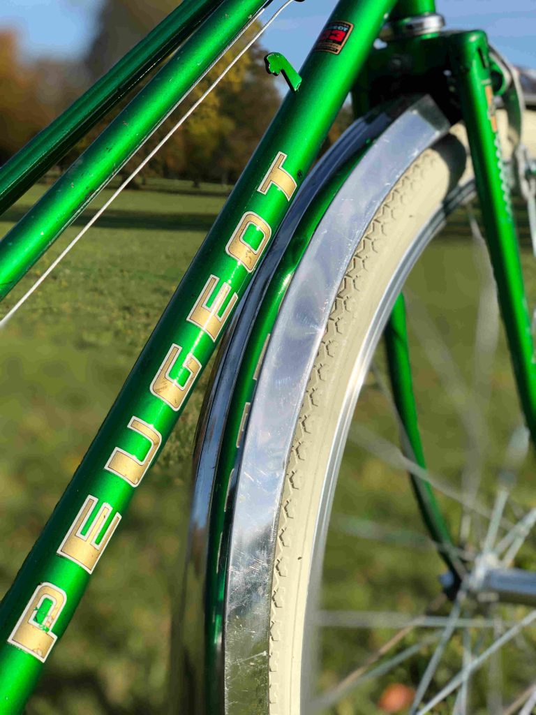 logo Peugeot inscrit sur le tube d'un cadre de vélo vert